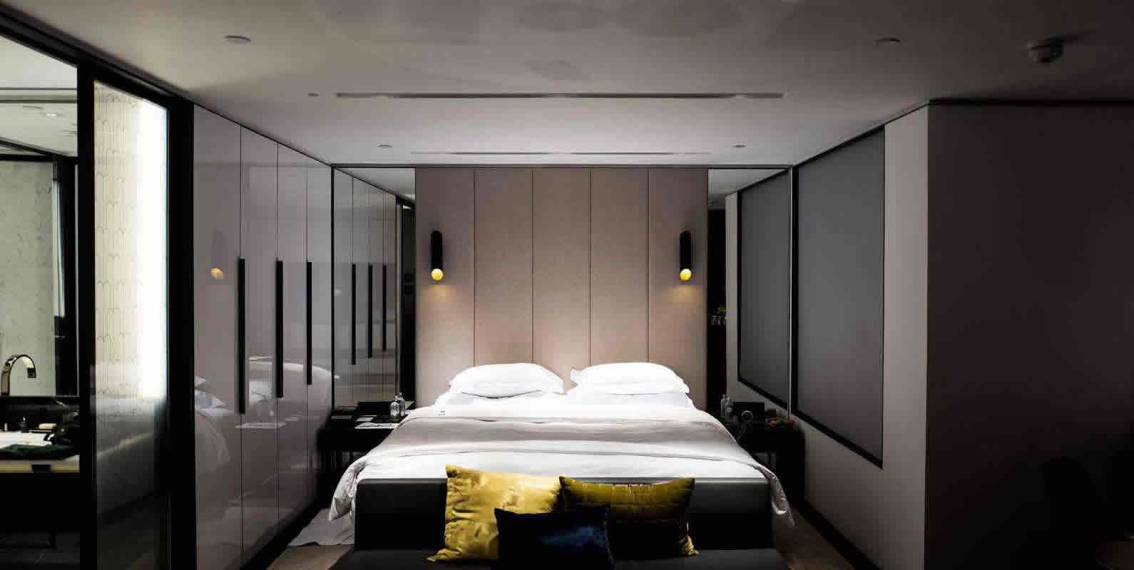 A contemporary bedroom with a large bed, minimalistic decor, and soft lighting, creating a serene and restful space.