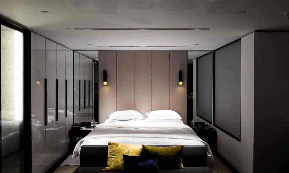 A contemporary bedroom with a large bed, minimalistic decor, and soft lighting, creating a serene and restful space.
